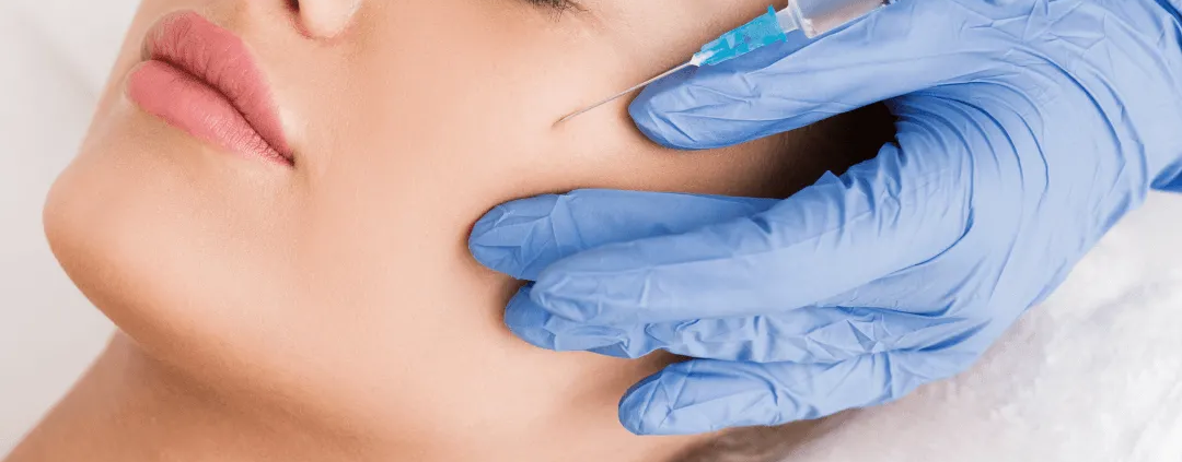Femme recevant des injections d’acide hyaluronique dans les pommettes chez un médecin esthétique à Paris
